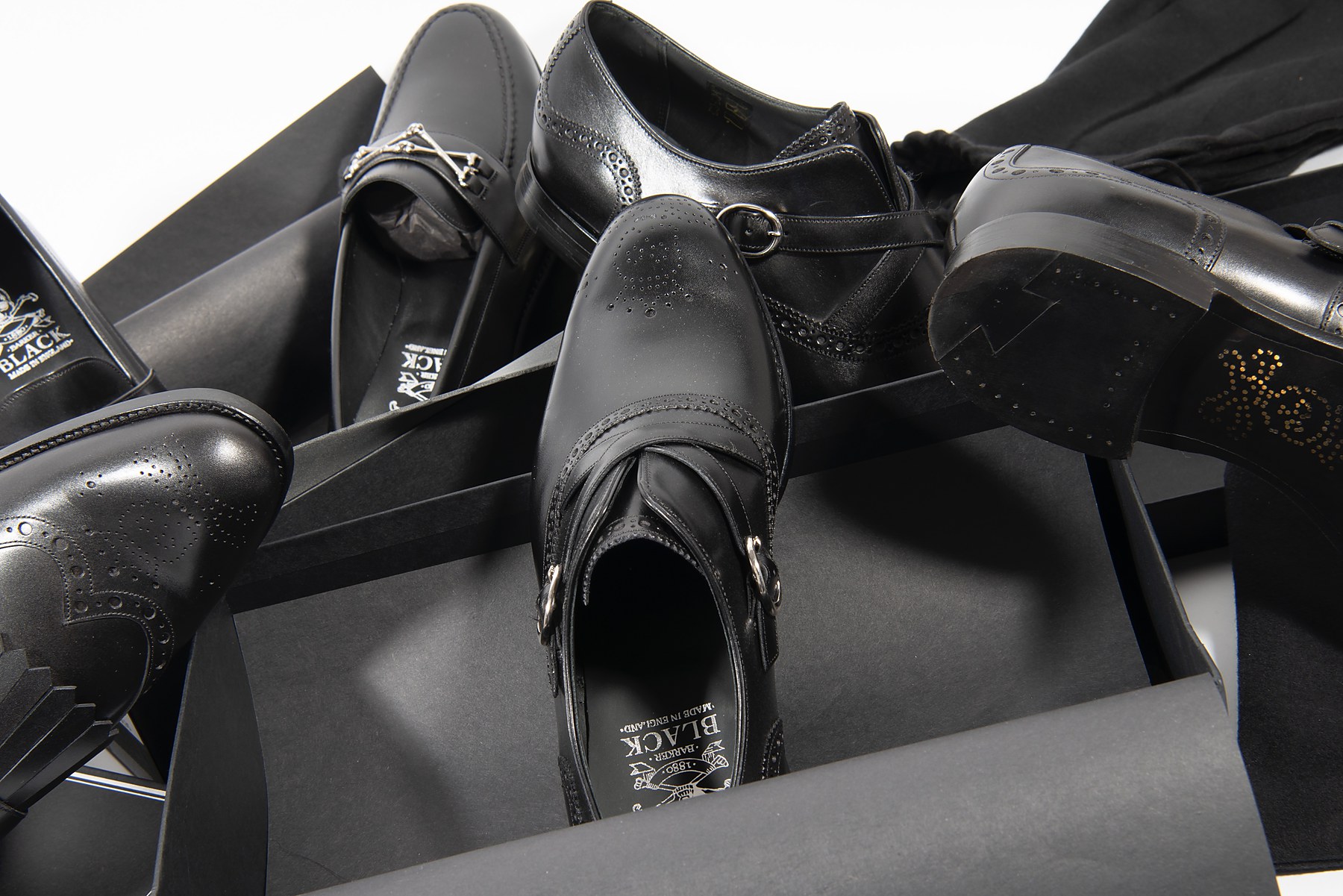 Black shoes and boots laid out with their boxes