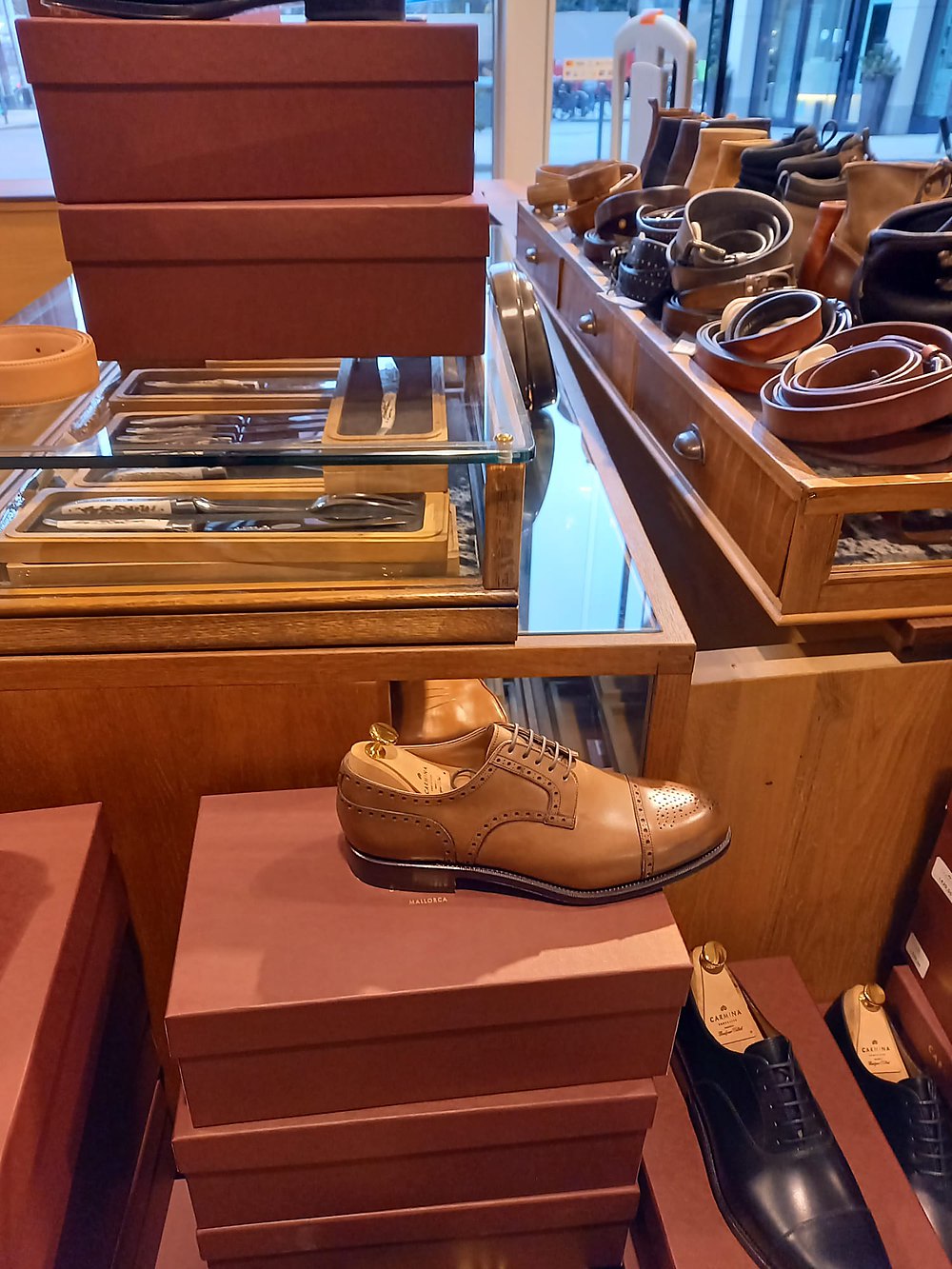 Shoe display on the shop floor — boxes, trees and lasts behind