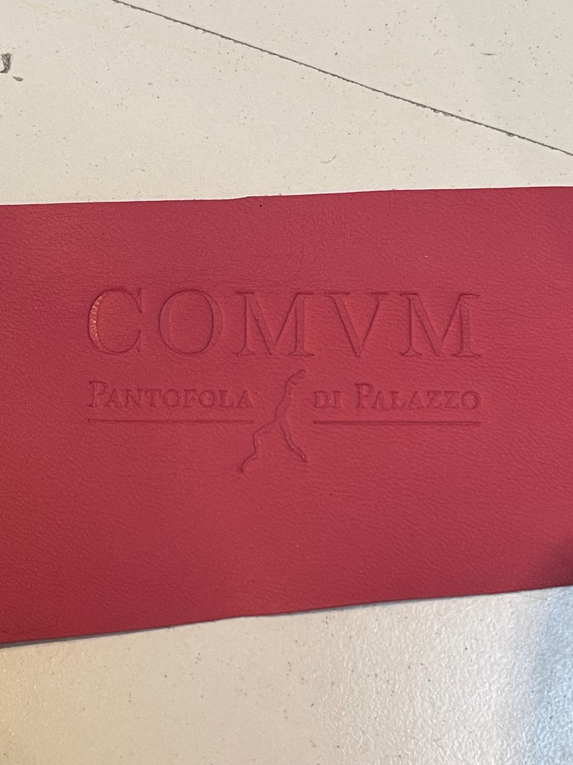 COMVM wordmark blind-embossed into red leather