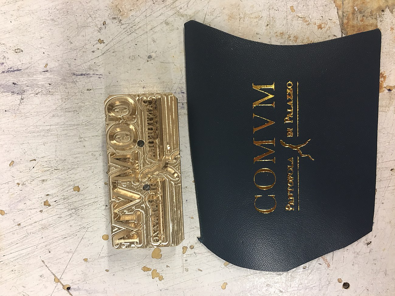 The brass stamp beside the finished gold impression