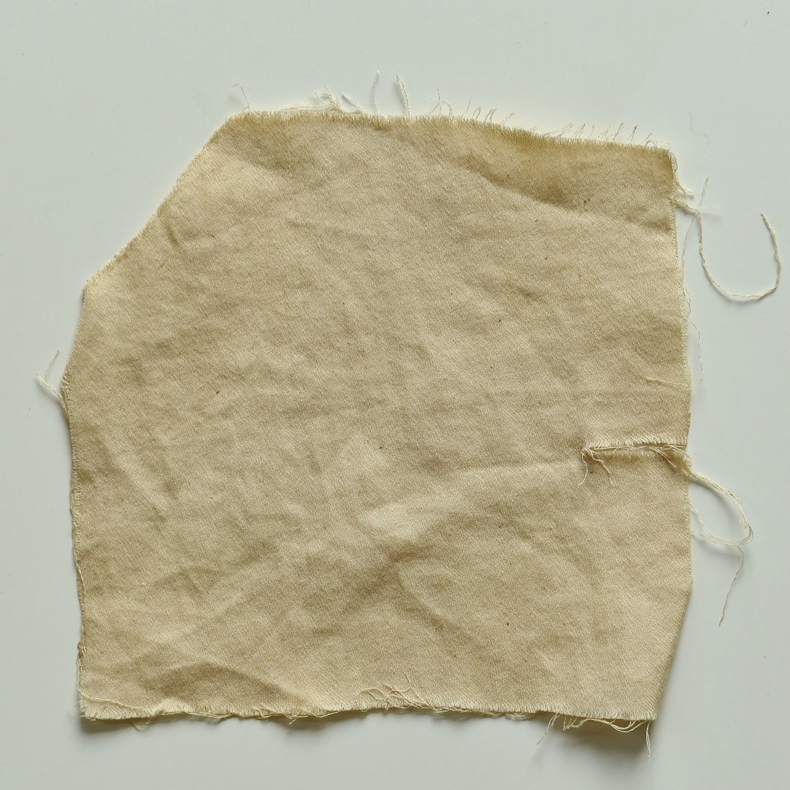 Cotton dyed with pomegranate after an alum mordant — barely coloured