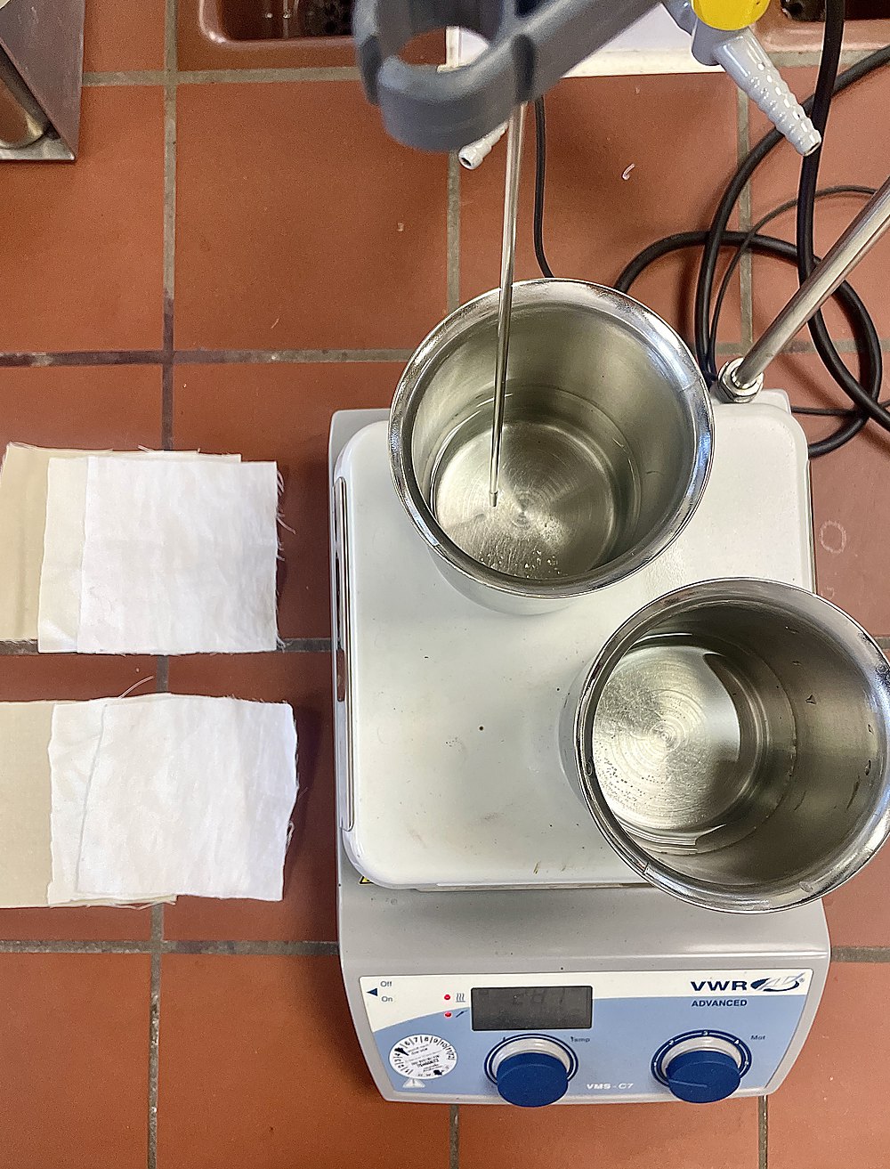 Heated stirring plate with two metal beakers holding the dye baths