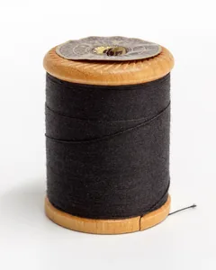 A wooden spool of black sewing thread